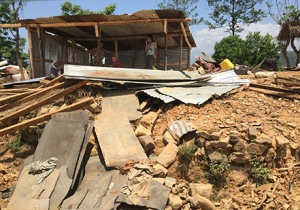 A family assesses the damage to their home in Sindhupalchowk, a district hit hard by the Nepal earthquake.(PHOTO COURTESY OF DINESH SUBEDI, MD)