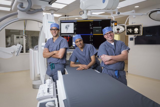 Hesham Masoud, MBBCh, Amar Swarnkar, MD and Grahame Gould, MD, in the bi-plane angiography operating room at Upstate University Hospital. Its location, in the new intraoperative MRI surgical suite, enables surgeons to obtain MRI scans during surgeries, improving patient outcomes.