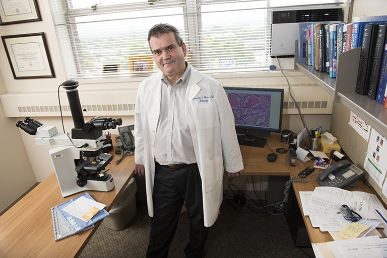 Anatomical pathologist Gustavo de la Roza, MD, in his office reviewing prostate cancer slides. He is one of the Best Doctors in America, a peer-review honor that recognizes approximately 5 percent of U.S. doctors from whom other doctors would seek care. (PHOTO BY SUSAN KAHN)