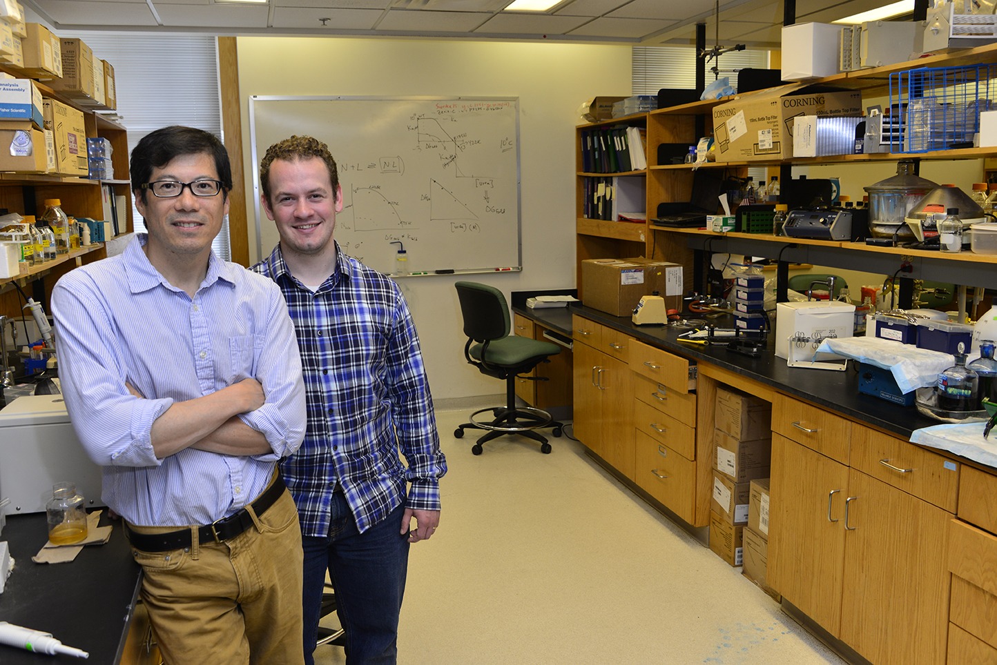 Stewart Loh, PhD (left), and Adam Blander in the lab where they are developing an experimental cancer drug that, in 10 years, may be used to repair a gene that is implicated in about half of all cancers. (PHOTO BY WILLIAM MUELLER)