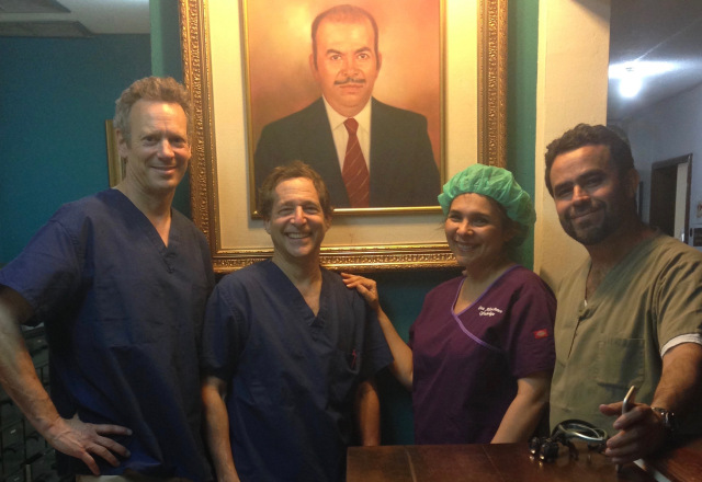 Syracuse ophthalmologists Thomas Bersani, MD, and Robert Wiesenthal, MD, with their Honduran colleagues Drs. Alicia Ponce and Luis Sanilo in from of a portrait of the clinic's founder, Luis Alberto Ponce.