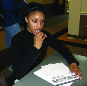 Tesha English collects tissue samples by swabbing her mouth with a Q-tip, a key component to registering as a marrow donor, 2008.