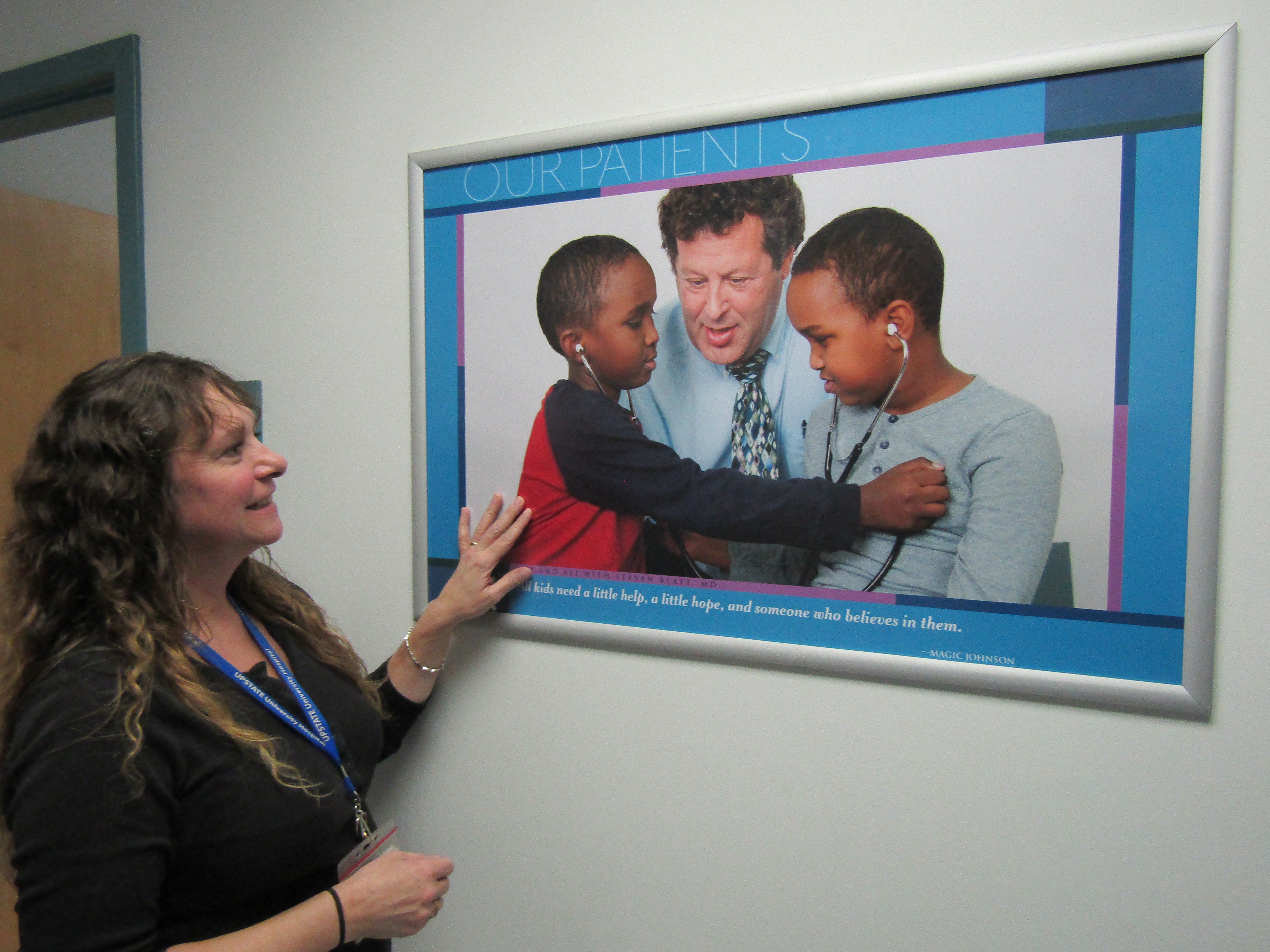 Kelly Dawn admires a new poster of patients Awi and Ali with Steven Blatt MD, medical director of Upstate‘s Pediatric and Adolescent Center.