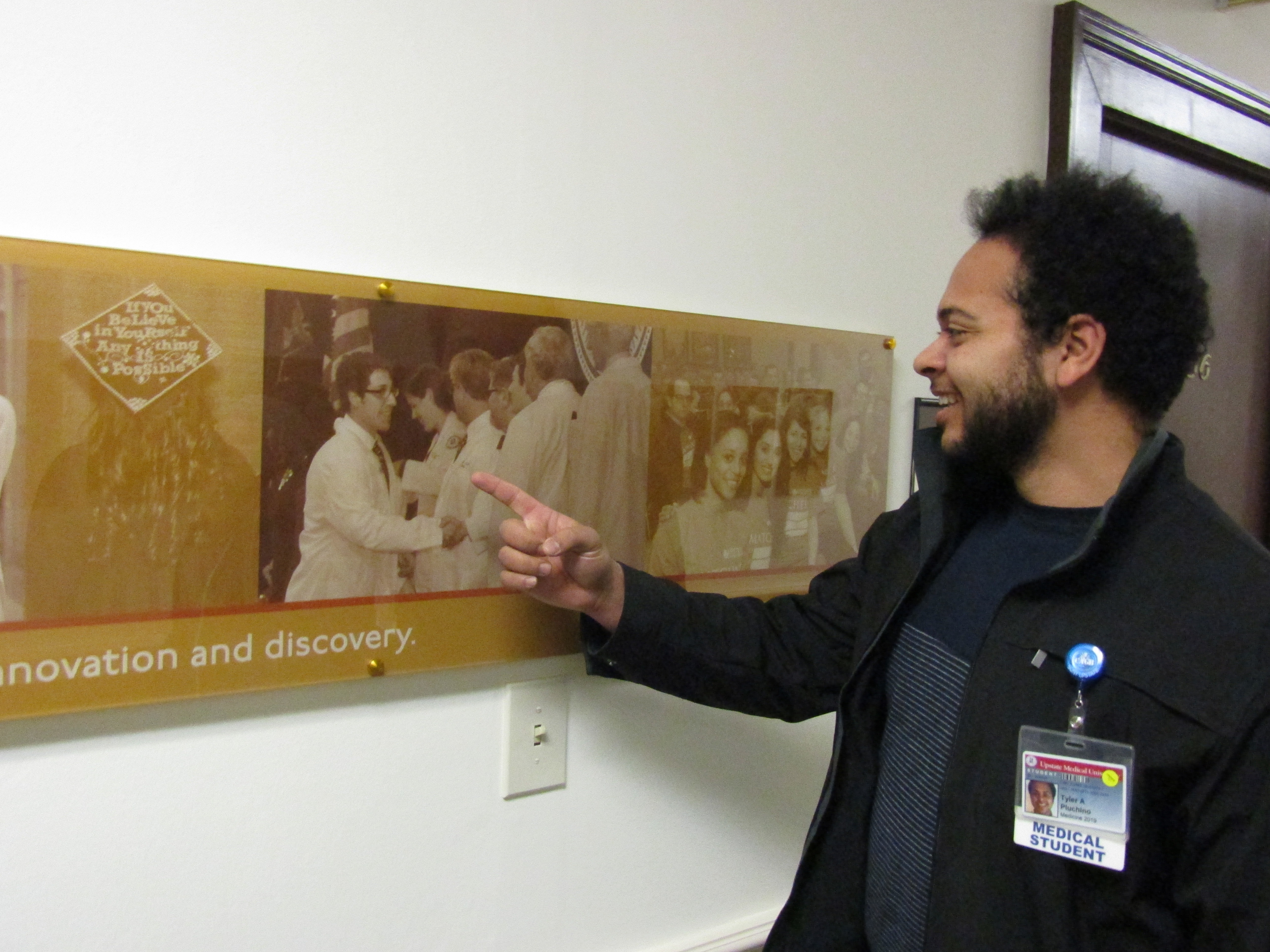 First-year medical student Tyler Pluchino recognizes his classmate, John Frandino, in one of the new student display panels in Weiskotten Hall.