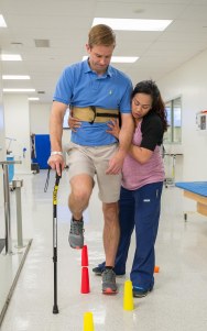 Physical therapist Daisy Sandbek works with Reger in University Hospital's Rehabilitation Center last September. (PHOTO BY ROBERT MESCAVAGE)