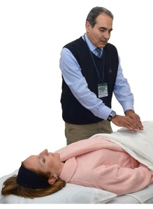 Gary Kassel demonstrates Reiki with patient Bailey Colvin at the Upstate Cancer Center.