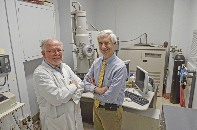 Donald Balir, MD, and Jerrold Abraham, MD, in their Upstate lab with the microscope they used to isolate the NY_v014 poxvirus. (PHOTO BY DEBORAH REXINE)