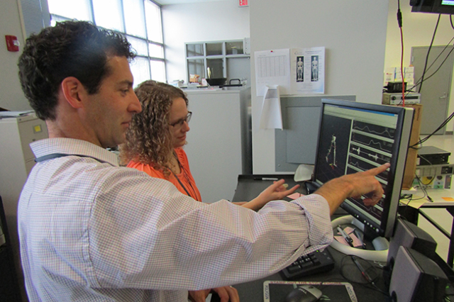 Christopher Neville, PT, PhD, and research assistant Julia Rogers in the Motion Analysis Lab at Upstate. They are reviewing files associated with Neville‘s studies on the mechanical effects of flatfoot deformity. Photo by Susan Keeter