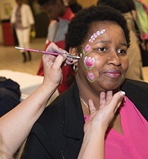Camilla Bowman, a 16-year cancer survivor, gets her face painted at the celebration.