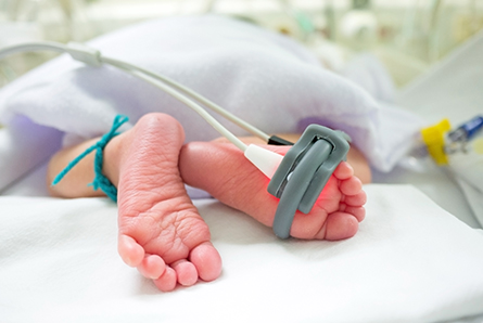 baby feet and oxygen saturation monitor
