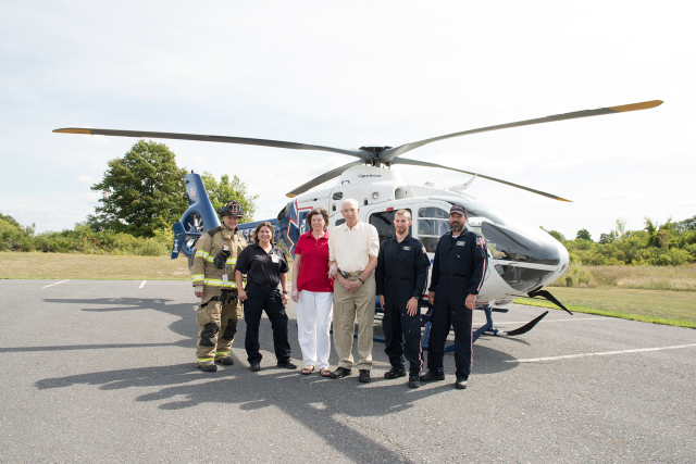 Larry Deshaw and his wife, Nancy Humphrey (center) reunited with rescuers in Clayton about a month after he suffered a stroke. This is the parking lot of the Clayton Fire Department, where the LifeNet helicopter picked Deshaw up to transport him to the comprehensive stroke center at Upstate.