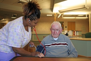 Nurse checking blood pressure on older gentleman