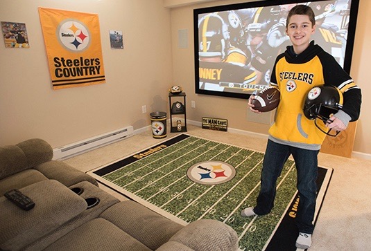 Parker Hysick in his Pittsburgh Steelers-themed man cave, a gift from Make a Wish Central New York. (PHOTOS BY SUSAN KAHN)