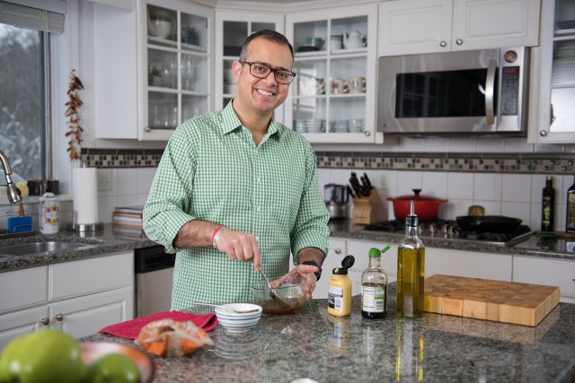 Prateek Wali, MD, in his kitchen preparing a marinade for salmon (see recipe below). (PHOTO BY SUSAN KAHN)