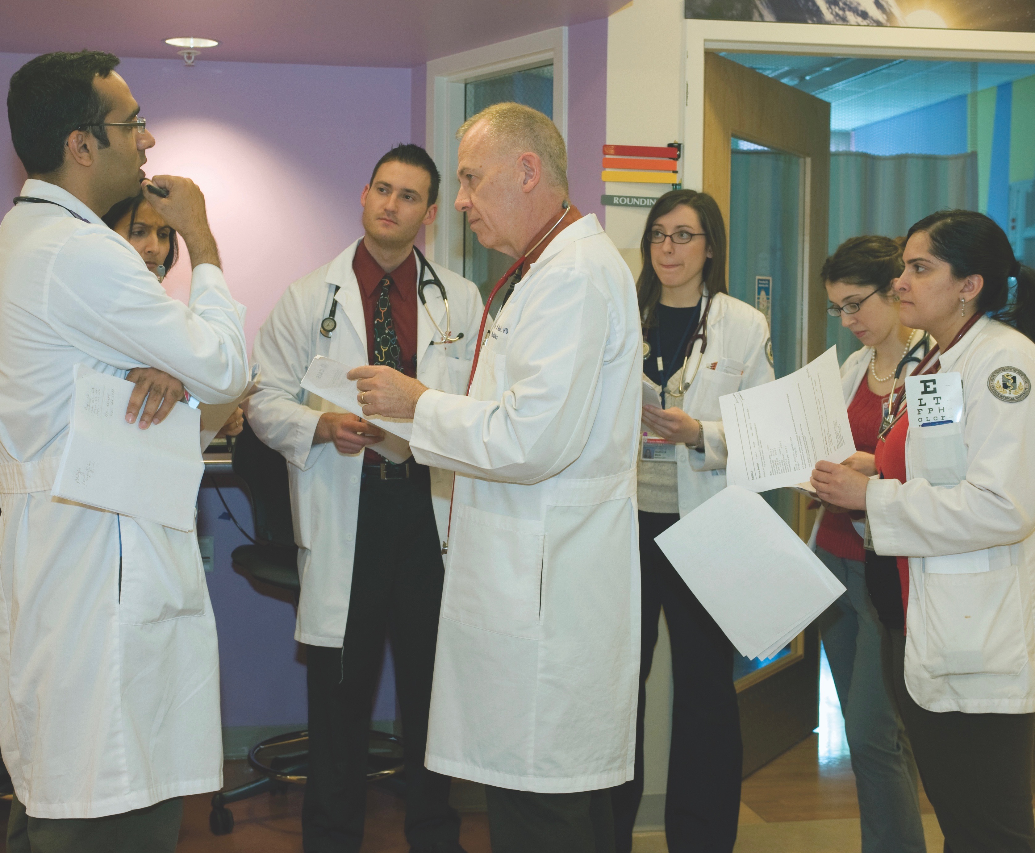 Thomas Welch, MD (center), with a group of medical residents and students at the Upstate Golisano Children's Hospital. (PHOTO BY SUSAN KAHN)