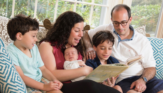 Upstate pediatrician Jaclyn Sisskind, MD, reads to her sons, Eli, Jacob and Ari, as her husband, Ben Gnacik, looks on. (PHOTO BY SUSAN KAHN)