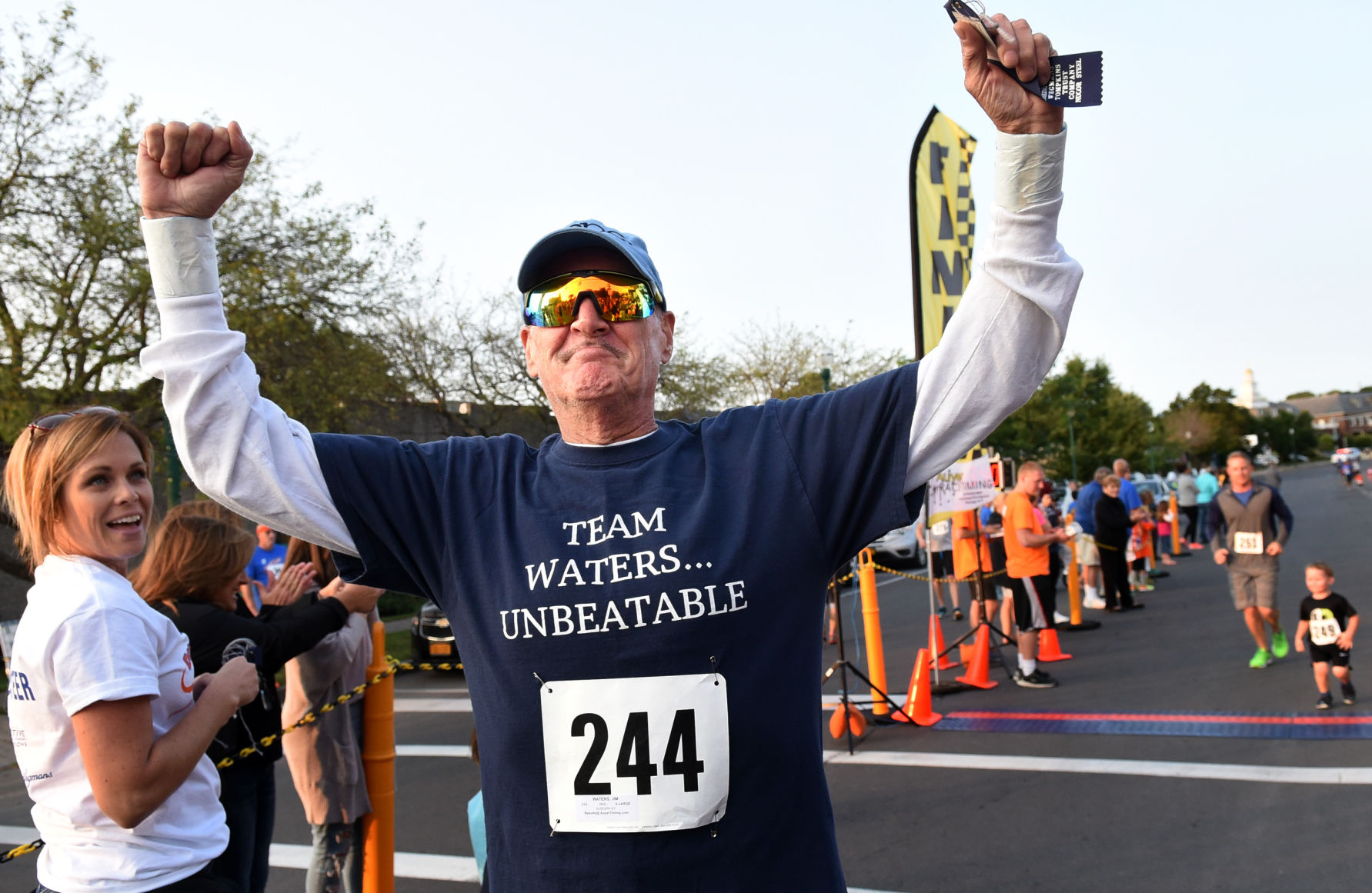 Jim Waters, who has stage IV colon cancer, raises his arms in victory after finishing the Downtown Auburn Mile in August. (PHOTO BY KEVIN RIVOLI/THE AUBURN CITIZEN/AUBURNPUB.COM)