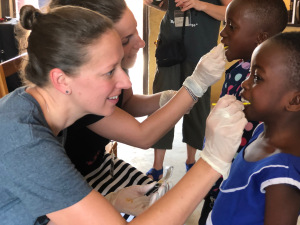 Meghan Lewis, an oncology nurse at Upstate, and Traci Bender, a social worker from Buffalo, give fluoride to two of the 372 students who received treatments. (PHOTO BY AGYAPONG GYAMFI)