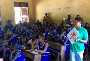 Maisha Brown, a pediatric nurse at Upstate, shows a chart of the reproductive system to female students at Fufulso Presbyterian Primary School. The students and teachers speaks different Ghanaian languages, but all read and speak English. (PHOTO BY MEGHAN LEWIS)