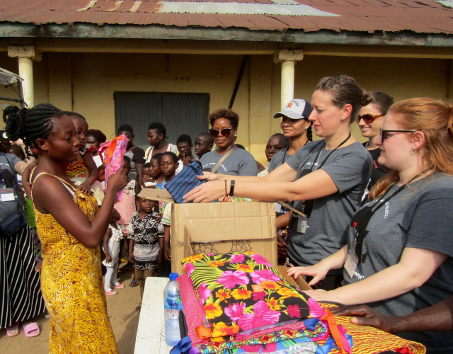 Upstate nurse Meghan Lewis gives a Days for Girls reusable menstrual kit to a young mother at a market in Kumasi, Ghana. (PHOTO BY SUSAN KEETER)