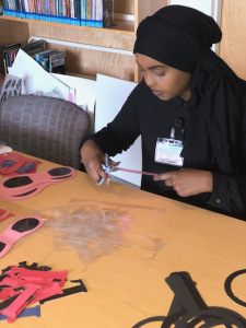 Muno Nuur, a Le Moyne College student, at work in the Family Resource Center at the Upstate Golisano Children's Hospital. (Photo by Amani Mike)