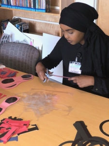 Muno Nuur, a Le Moyne College student, at work in the Family Resource Center at the Upstate Golisano Children's Hospital. (Photo by Amani Mike)