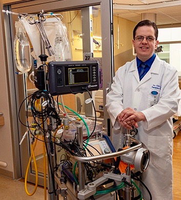 Christopher Tanski, MD, with the ECMO machine. (Photo by William Mueller)