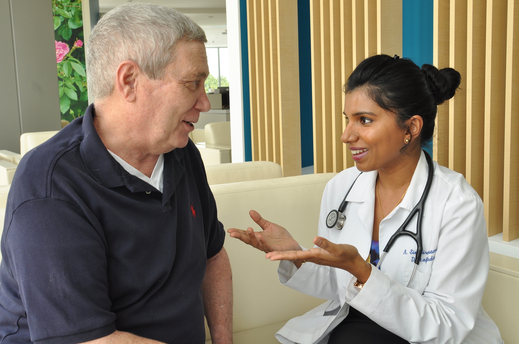 Eugene Young talks with his oncologist, Abi Siva, MD, about encouraging results of immunotherapy medication. (photo by Richard Whelsky)