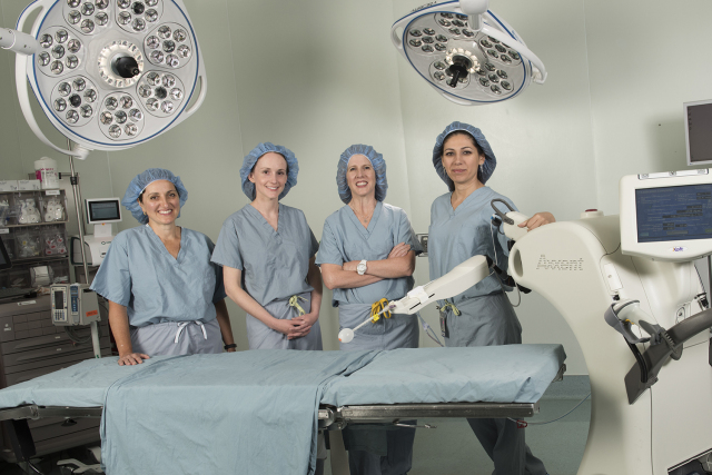 From left, breast surgeons Mary Ellen Greco, MD, Lisa Lai, MD, and Kristine Keeney, MD, and radiation oncologist Anna Shapiro, MD, in the operating room with the new intraoperative radiation therapy unit. (photos by Susan Kahn)