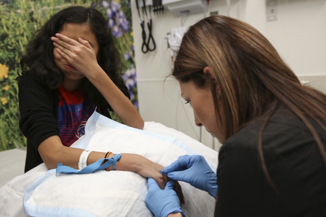 Nurse Kristen Thomas draws Lola‘s blood for tests at Upstate after six weeks of radiation.