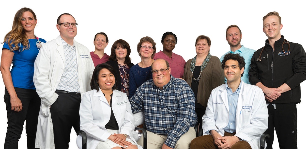 Members of Upstate‘s stroke team who had a role in caring for patient Dave Cartner include: seated from left, Claribel Wee, MD, neurology resident physician, Cartner, and Hesham Masoud, MD, stroke neurologist. Standing from left, nurse Lauren Kaul, emergency department, Grahame Gould, MD, neurosurgeon, Jessica Guido, X-ray technologist, nurse Michelle Vallelunga, stroke program data coordinator, Shirley Cartner, the patient‘s wife, Shantel Henry, X-ray technologist, nurse Patricia Veinot, stroke data coordinator, nurse Josh Onyan, stroke program manager, and Theodore Albright, MD, emergency medicine resident physician. (photo by Robert Mescavage)