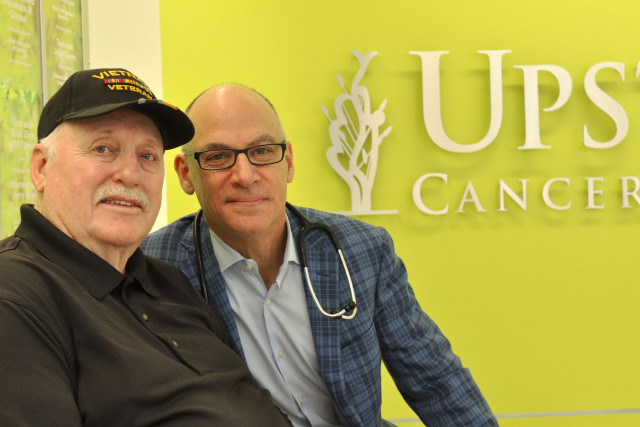 Jan Roberts, left, with radiation oncologist Jeffrey Bogart, MD. Roberts wears a cap that honors those, like him, who served in Vietnam, especially those who didn‘t come back. (photo by Richard Whelsky)