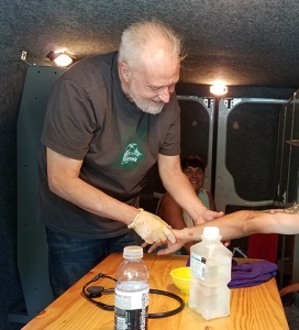 Using a van as a patient room, Lehmann examines a homeless man‘s wounds. (photo by Robert Mescavage)