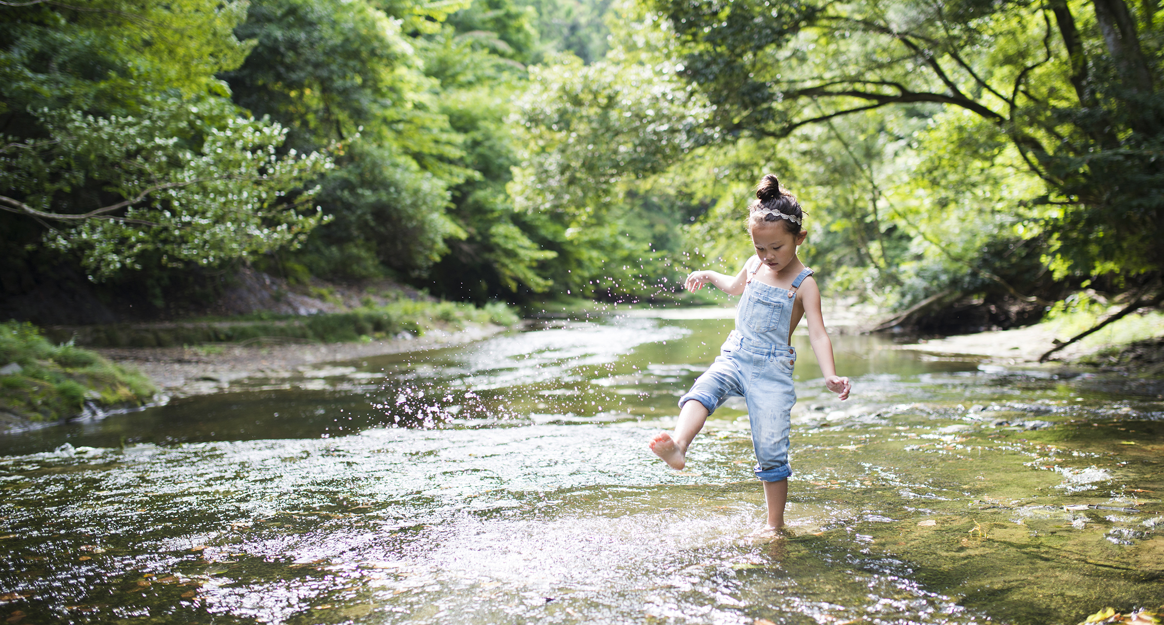 Little girl playing on a stream