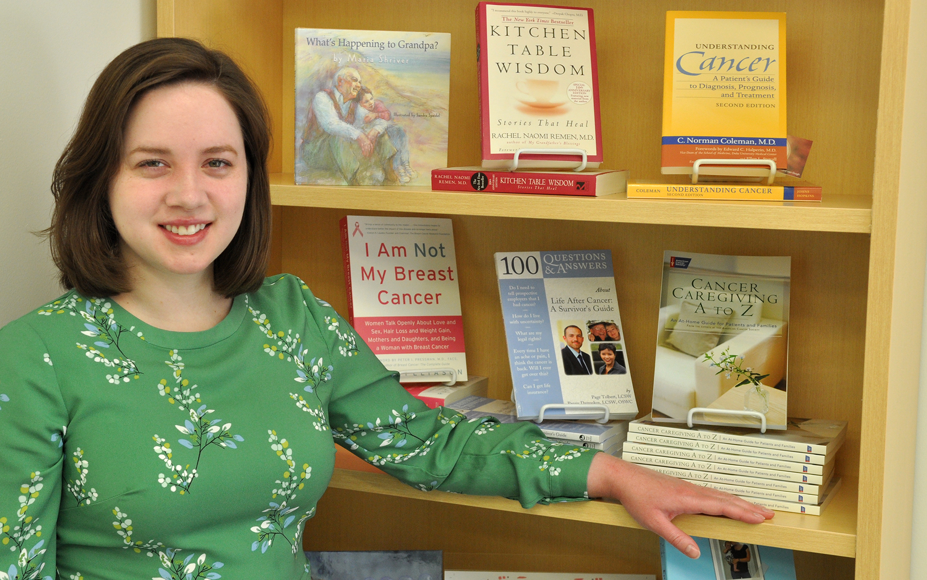 Librarian Sarah Lawler with free books that are available at the Upstate Cancer Center. The Family Resource Center has computers so that Lawler can assist staff, patients and family members with online searches. (photo by Richard Whelsky)