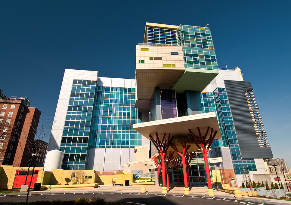 From the outside, the Upstate Golisano Children’s Hospital looks as though it was snapped together with brightly colored toys. To enter, you walk past the red trunks of several “trees” holding up the roof and into elevators that go directly to the “treehouse” on the 11th and 12th floors. (photo by Robert Mescavage)