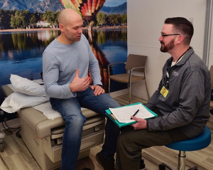 Kosick, left, speaks with nurse Christopher White, part of the Survivor Wellness Program team, during an annual visit to the Upstate Cancer Center. (photo by Debbie Rexine)