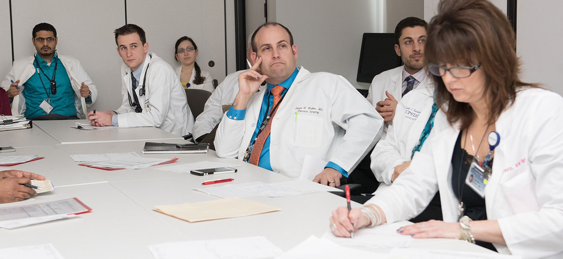 Jason Wallen, MD, center, contemplates a treatment plan for a lung cancer patient during a TOP multidisciplinary team meeting. (photo by Susan Kahn)