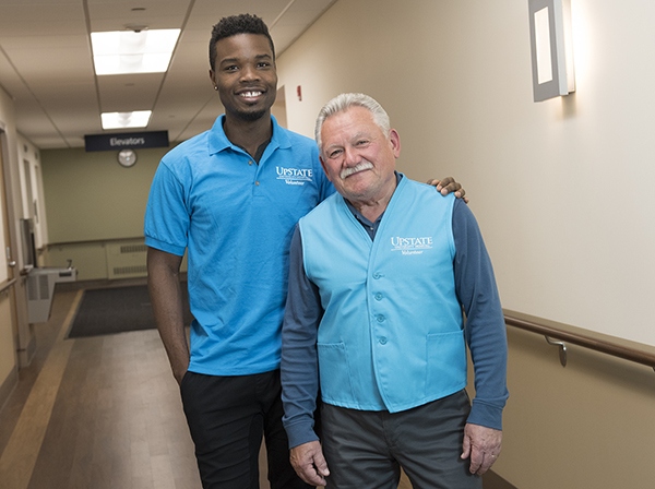 Halleluyah “Lou” Adebiyi, left, and Stanley Simon model the new Upstate volunteer uniforms. PHOTO BY SUSAN KAHN