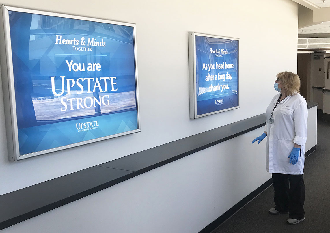 Catherine Disalto reads a sign that says, “As you head home after a long day, thank you” -- one of many posted throughout the hospital by administrators.