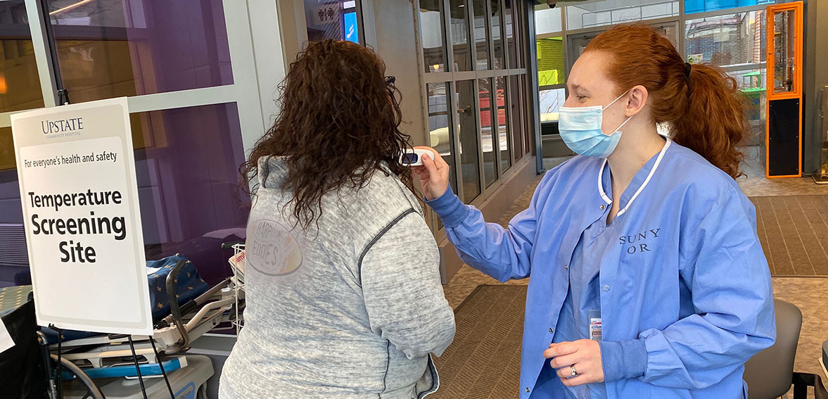 Bryttnaye Karker from outpatient surgery takes the temperature of people entering the Upstate Golisano Children's Hospital. (photo by Maisha Brown)