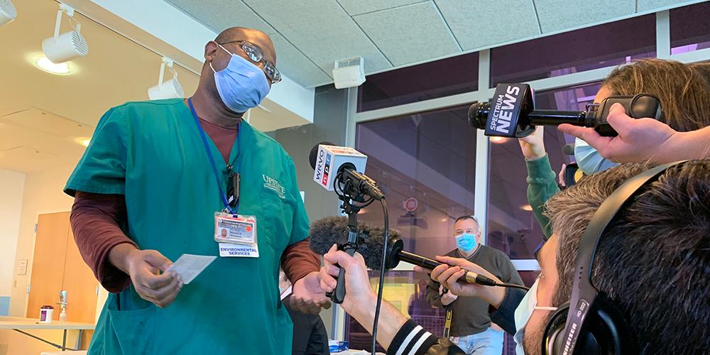 Kenzo Mukendi, an environmental services staffer at Upstate University Hospital who was the first person in Central New York to receive the COVID-19 vaccine, is interviewed by the news media on Dec. 15, 2020.