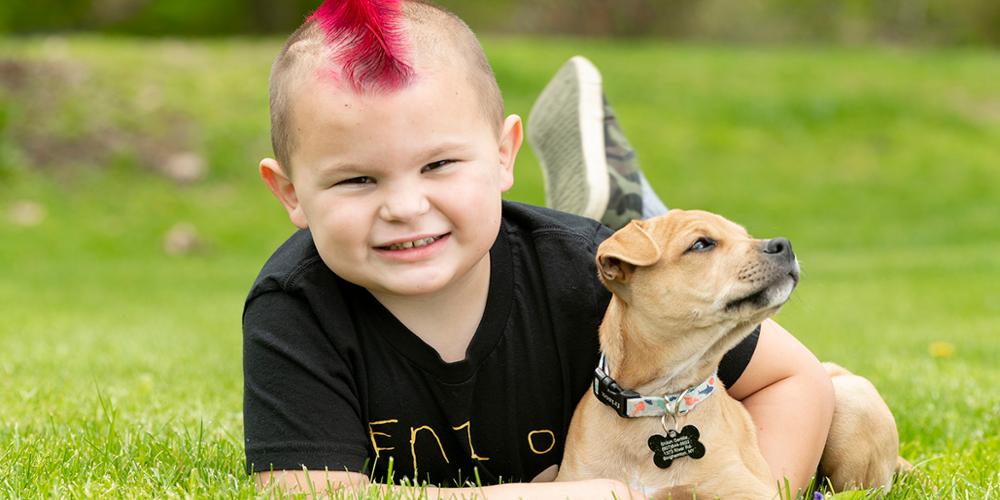 Enzo Gentile, now 5, wears an “Enzo Strong” shirt while playing with his puppy, Tank. (photo by Robert Mescavage)