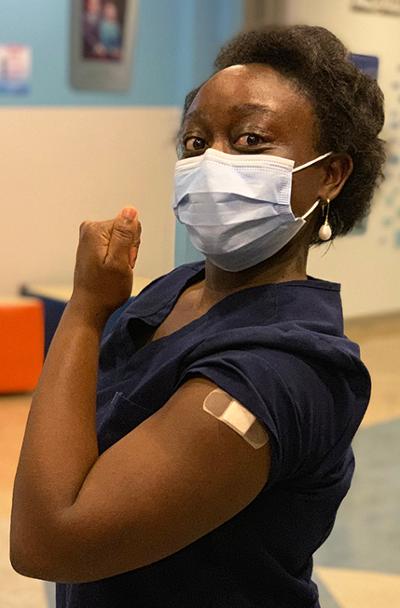 Upstate nurse practitioner Aisha Lubega strikes a "We can do it!" pose after getting her COVID-19 vaccine. (photo by Kathleen Paice Froio)