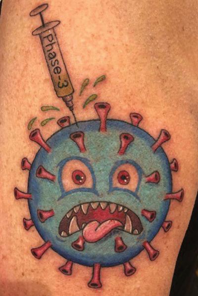 Becky Hogle, who took part in a COVID vaccine trial,   has a tattoo of a COVID-19 virus looking scared as it receives a dose of the vaccine.