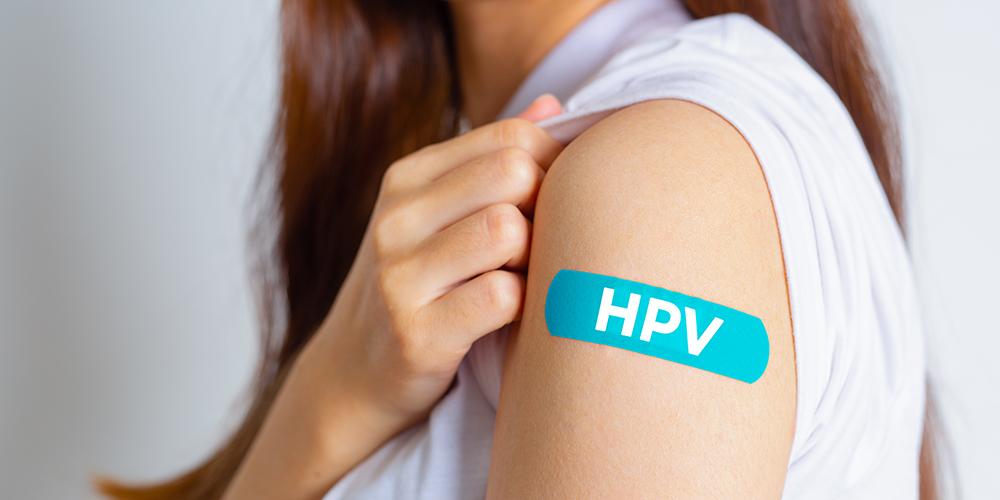 Arm with bandage that says "HPV" to show where an HPV vaccine was given.