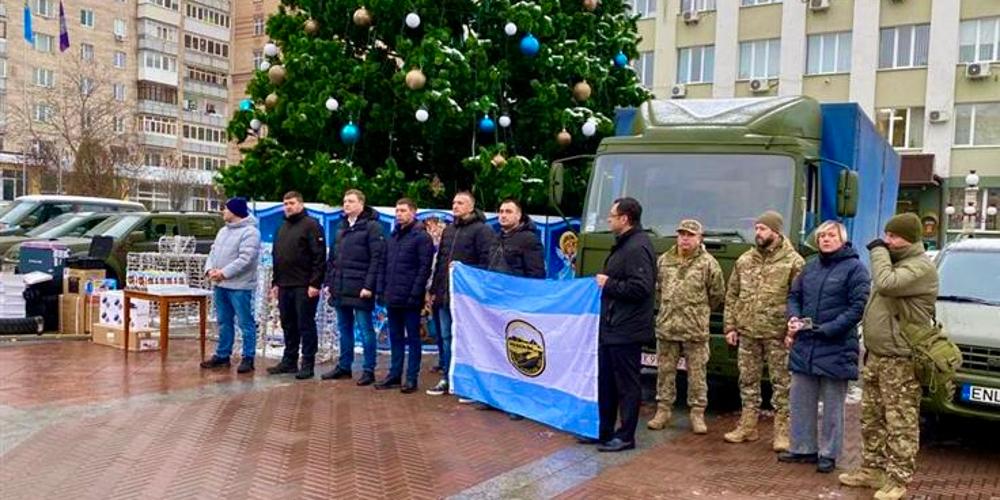 A ceremony in central Irpin marking the Ukraine1991 Foundation’s donations of pickup trucks and other groups’ gifts. Bratslavsky, fifth from right, holds a Syracuse city flag.